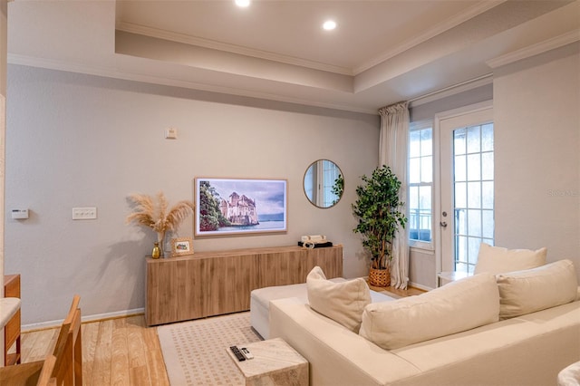 living room featuring crown molding, light wood-style flooring, recessed lighting, baseboards, and a tray ceiling