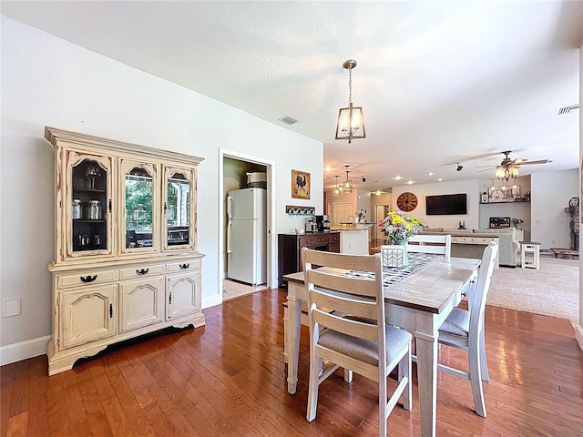 16224 Iola Woods Trl, Dade City, FL 33523 - dining room featuring baseboards, ceiling fan with notable chandelier, dark wood-style flooring, and visible vents