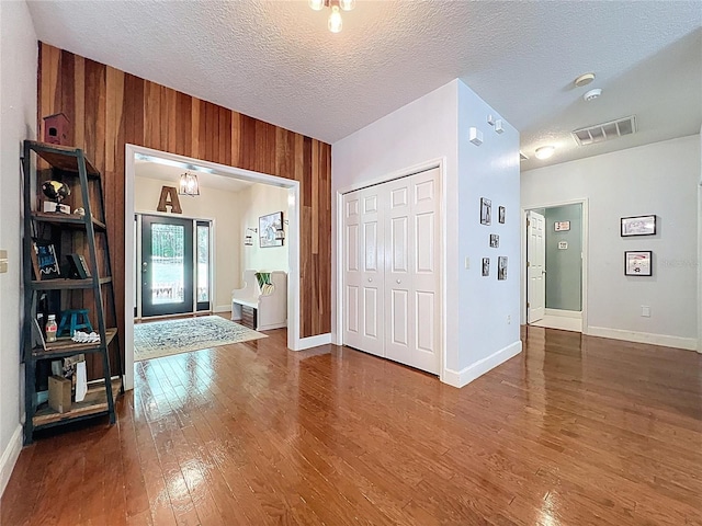16224 Iola Woods Trl, Dade City, FL 33523 - entryway featuring visible vents, baseboards, dark wood-type flooring, and wooden walls