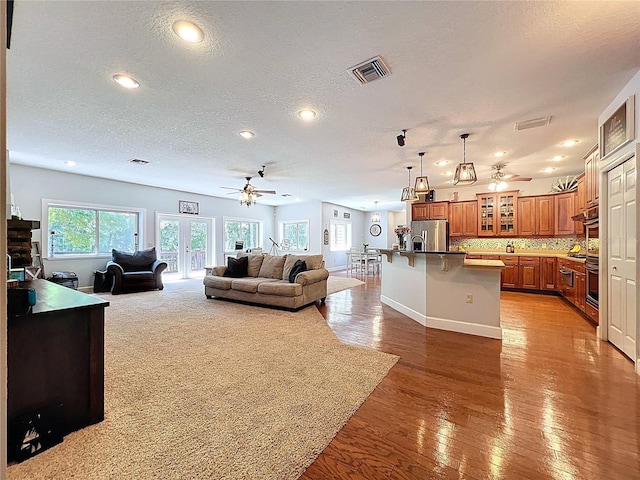 16224 Iola Woods Trl, Dade City, FL 33523 - living room with visible vents, ceiling fan, recessed lighting, light wood-type flooring, and a textured ceiling