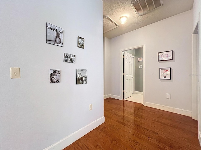 16224 Iola Woods Trl, Dade City, FL 33523 - hall with baseboards, visible vents, a textured ceiling, and wood finished floors