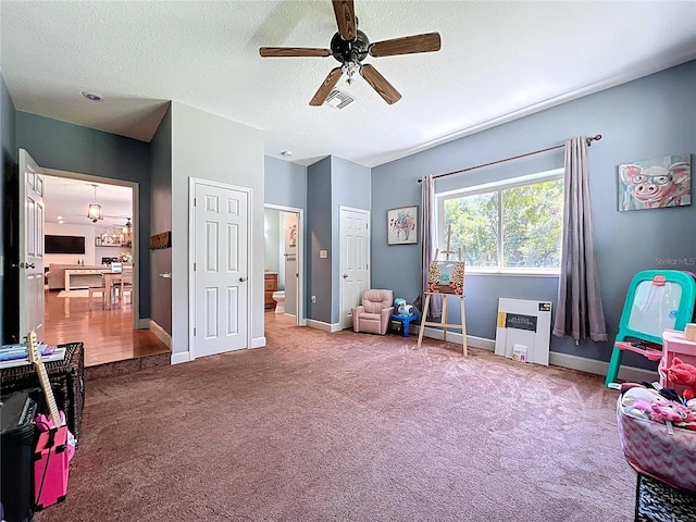 16224 Iola Woods Trl, Dade City, FL 33523 - rec room with ceiling fan, a textured ceiling, visible vents, baseboards, and carpet flooring
