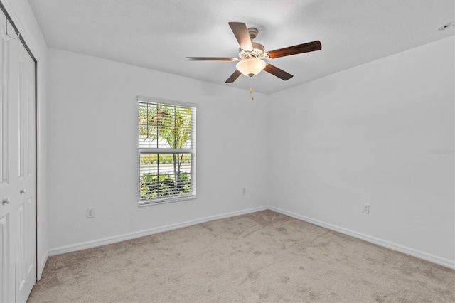 unfurnished bedroom featuring a closet, carpet, baseboards, and a ceiling fan