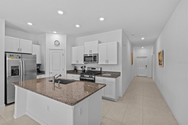 kitchen with a sink, stainless steel appliances, and white cabinetry