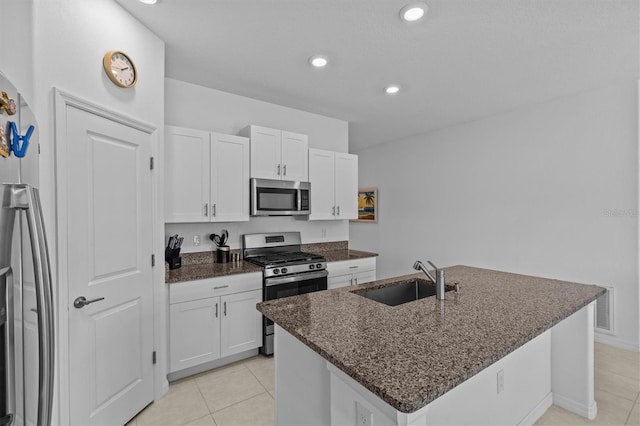 kitchen with a sink, white cabinetry, appliances with stainless steel finishes, and light tile patterned floors