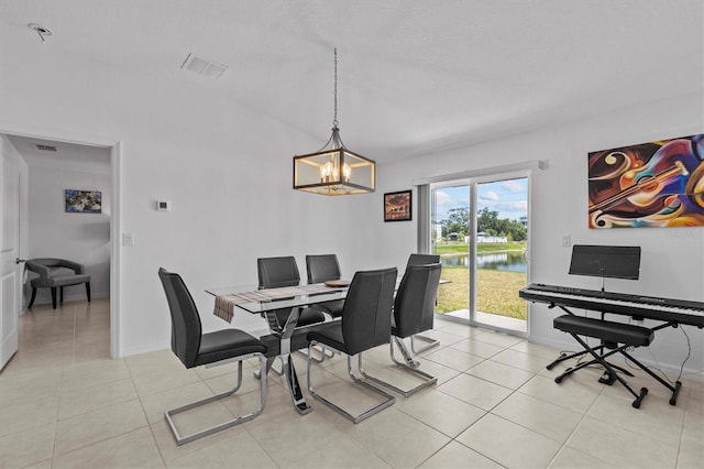 dining space featuring visible vents, baseboards, a chandelier, a water view, and light tile patterned flooring