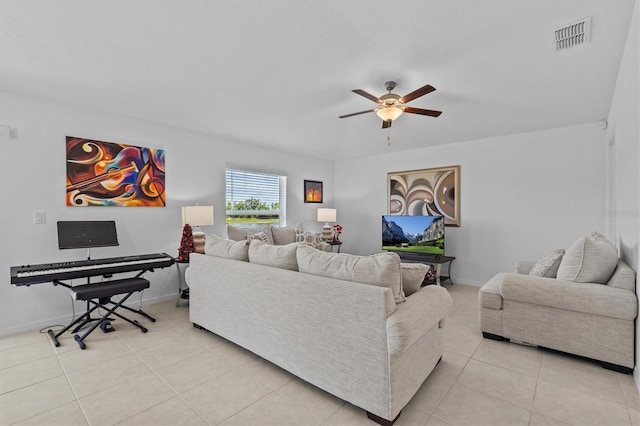 living area featuring a ceiling fan, baseboards, visible vents, and light tile patterned floors