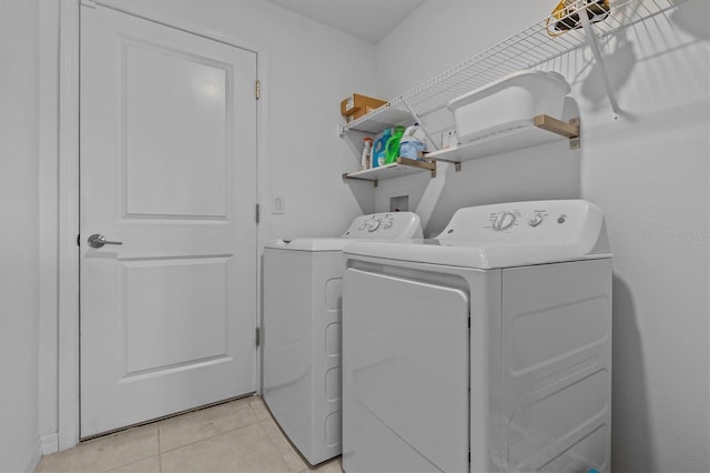 laundry area with independent washer and dryer, laundry area, and light tile patterned floors
