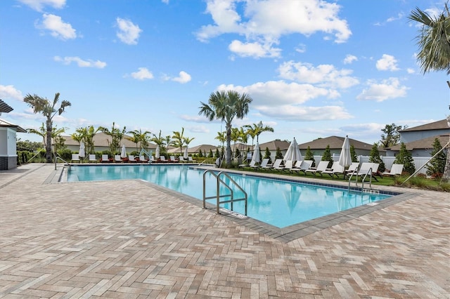 pool with fence, a patio, and a residential view