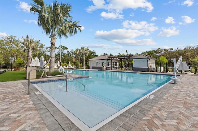 pool with fence, a pergola, and a patio