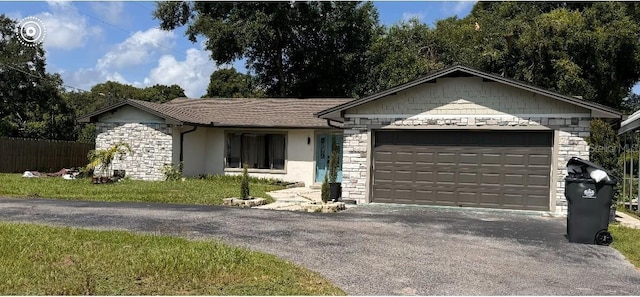ranch-style home featuring stucco siding, driveway, stone siding, and a garage
