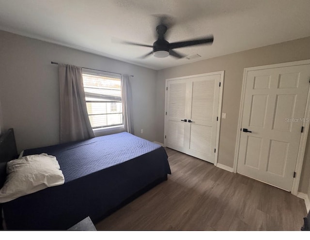 bedroom featuring baseboards, ceiling fan, a closet, and wood finished floors