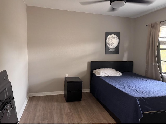 bedroom with baseboards, a ceiling fan, and wood finished floors