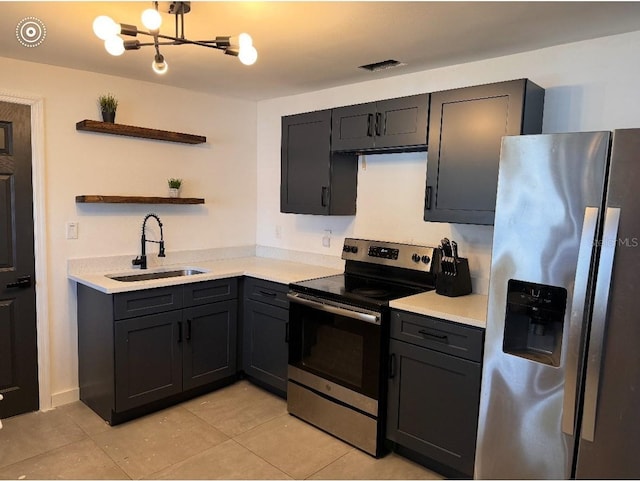 kitchen featuring appliances with stainless steel finishes, open shelves, a sink, light tile patterned floors, and light countertops