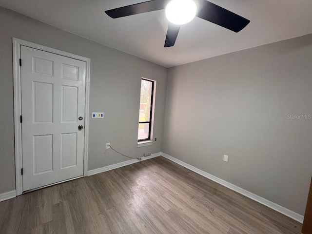 unfurnished room featuring baseboards, ceiling fan, and wood finished floors