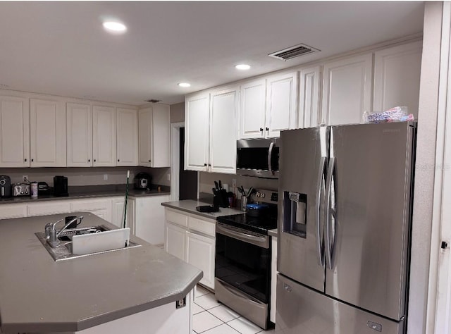 kitchen with stainless steel appliances, white cabinetry, and a sink