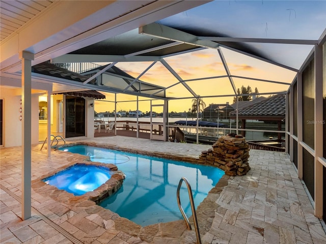 view of swimming pool featuring a pool with connected hot tub, a patio area, and a lanai