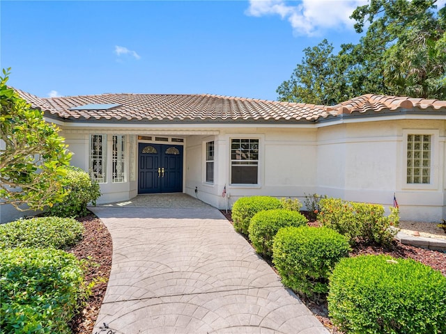 view of front of home featuring stucco siding and a tiled roof