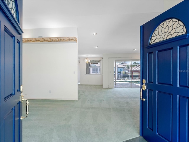 carpeted entrance foyer featuring an inviting chandelier and recessed lighting