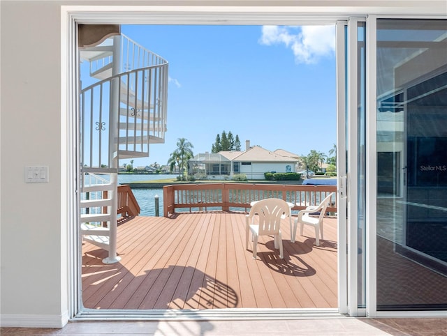 wooden terrace with a water view and stairway
