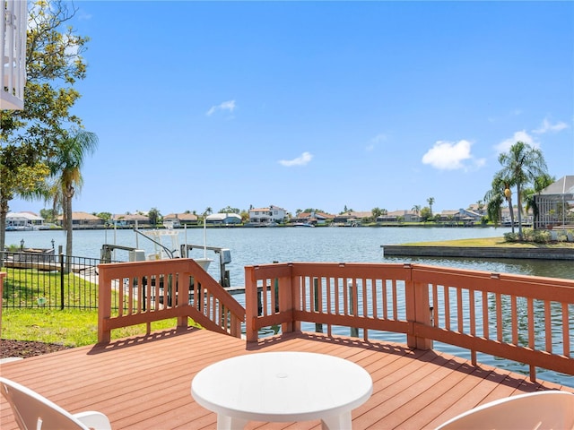 deck with boat lift, a water view, and a dock