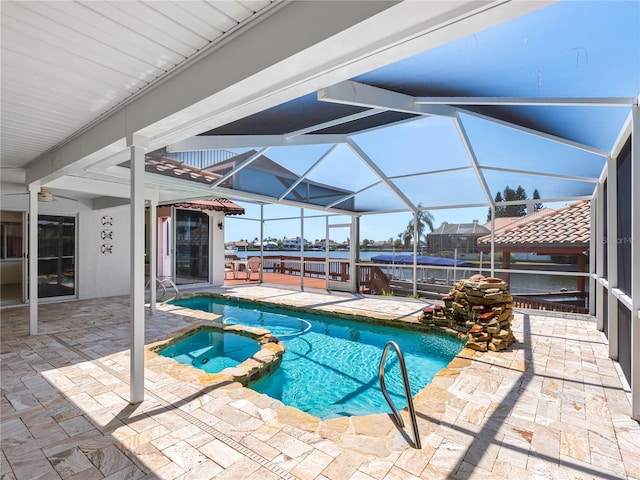 view of swimming pool with a pool with connected hot tub, a patio area, and a lanai