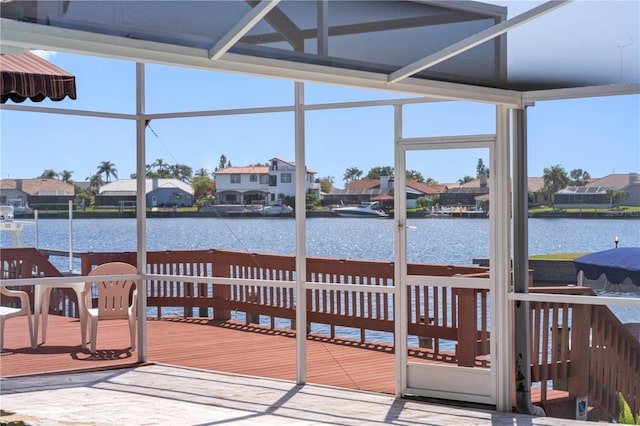 view of dock with a deck with water view and a residential view