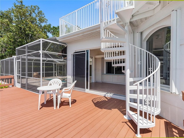 wooden terrace with a pool, a lanai, and stairs