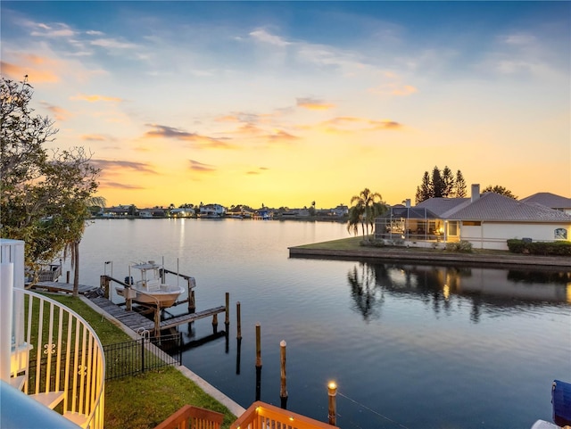 dock area featuring a water view, fence, and boat lift