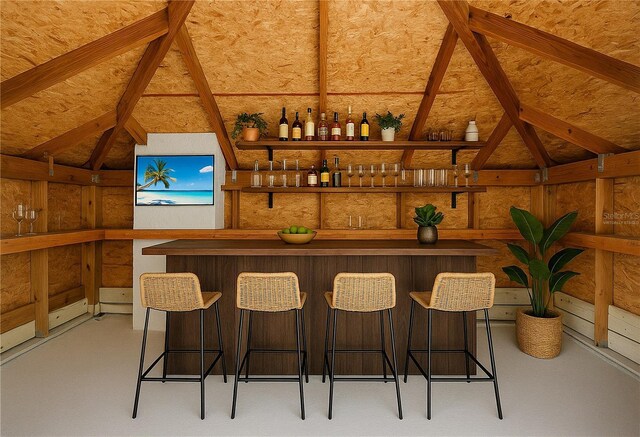 bar with vaulted ceiling and indoor wet bar