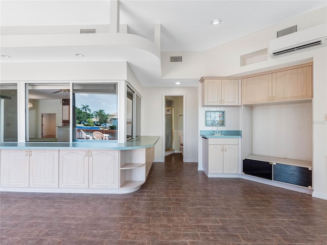 kitchen with recessed lighting, an AC wall unit, visible vents, and light brown cabinetry