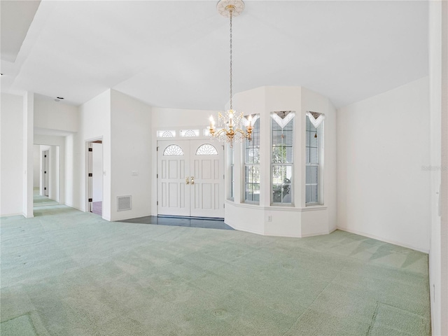 interior space featuring carpet flooring, a chandelier, visible vents, and vaulted ceiling