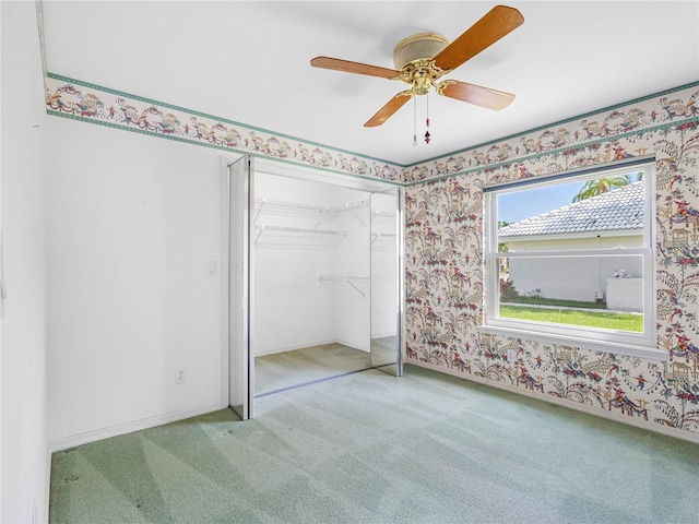 unfurnished bedroom featuring a ceiling fan, carpet flooring, a closet, and wallpapered walls