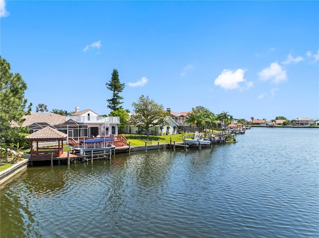 dock area with a gazebo, a water view, and a residential view