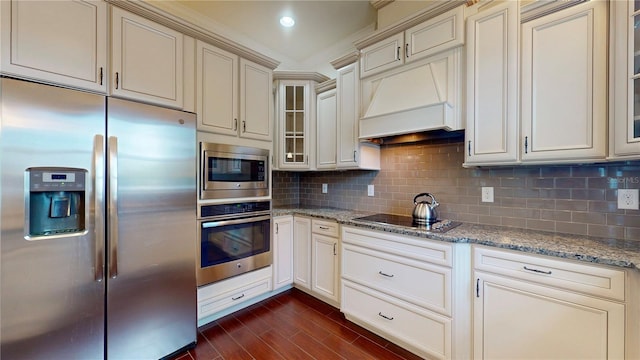 3615 S Church Ave, Tampa, FL 33629 - kitchen featuring stainless steel appliances, cream cabinetry, light stone counters, dark wood-style flooring, and glass insert cabinets