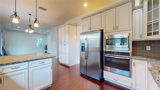 3615 S Church Ave, Tampa, FL 33629 - kitchen featuring stainless steel appliances, dark wood-type flooring, tasteful backsplash, cream cabinets, and light stone counters