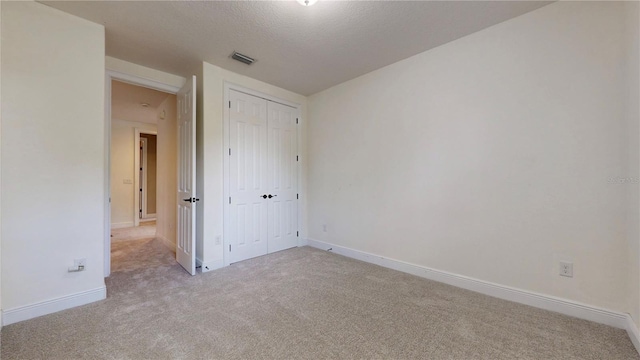 3615 S Church Ave, Tampa, FL 33629 - unfurnished bedroom with light carpet, a textured ceiling, baseboards, and a closet