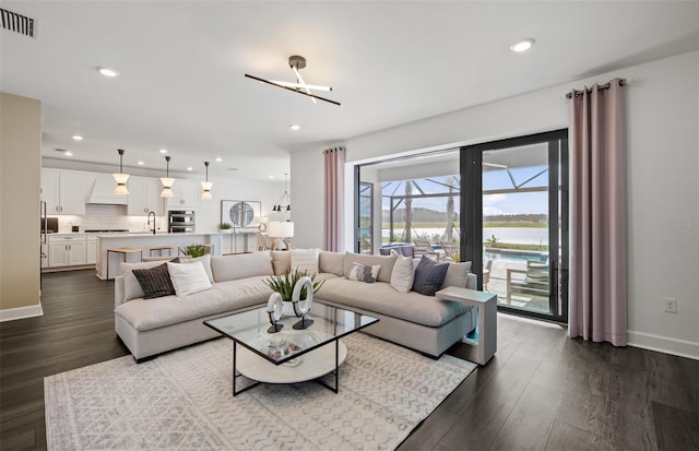 5949 Bluestar Ct, Lakewood Ranch, FL 34211 - living room featuring visible vents, baseboards, dark wood-type flooring, recessed lighting, and a water view
