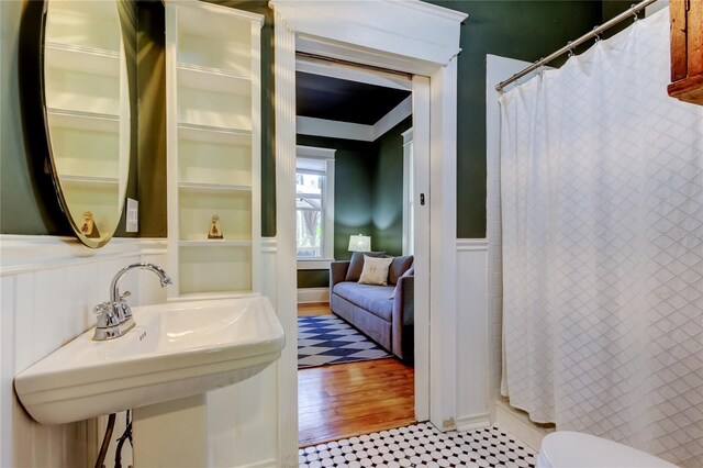 6341 Discovery Ln, Land O Lakes, FL 34638 - bathroom with wainscoting, a shower with shower curtain, a sink, toilet, and a decorative wall