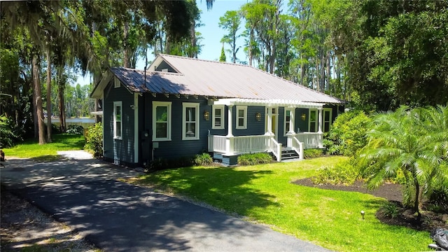 6341 Discovery Ln, Land O Lakes, FL 34638 - view of front of property with covered porch, a front lawn, metal roof, and a water view