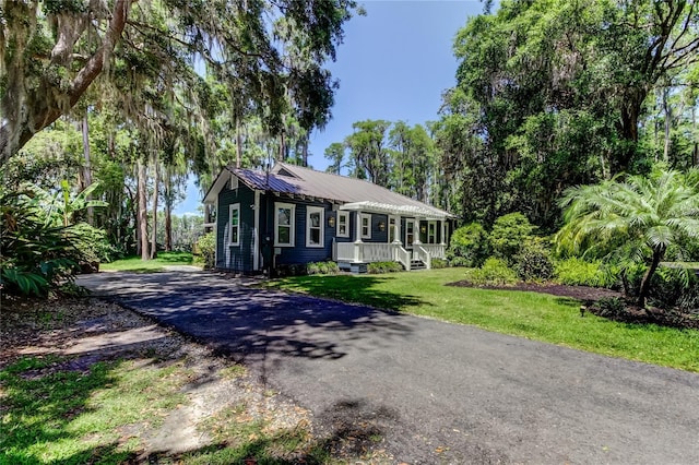 6341 Discovery Ln, Land O Lakes, FL 34638 - ranch-style home featuring metal roof, a front lawn, and asphalt driveway