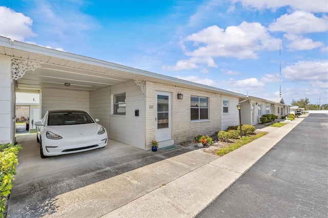 12400 Park Blvd Unit 210, Seminole, FL 33772 - view of property exterior featuring an attached carport and concrete driveway