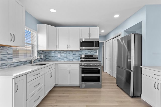 12400 Park Blvd Unit 210, Seminole, FL 33772 - kitchen featuring light countertops, white cabinets, a sink, backsplash, and stainless steel appliances