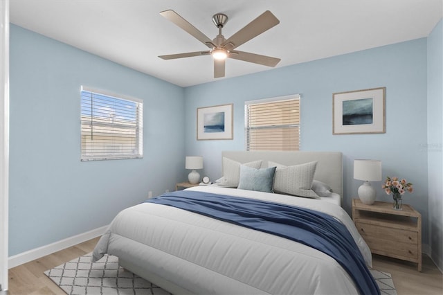 12400 Park Blvd Unit 210, Seminole, FL 33772 - bedroom featuring baseboards, ceiling fan, and light wood-style flooring