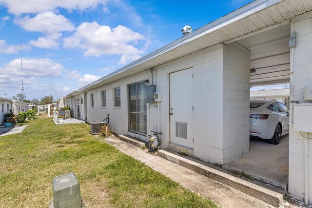 12400 Park Blvd Unit 210, Seminole, FL 33772 - exterior space with central AC unit, concrete block siding, visible vents, and a yard