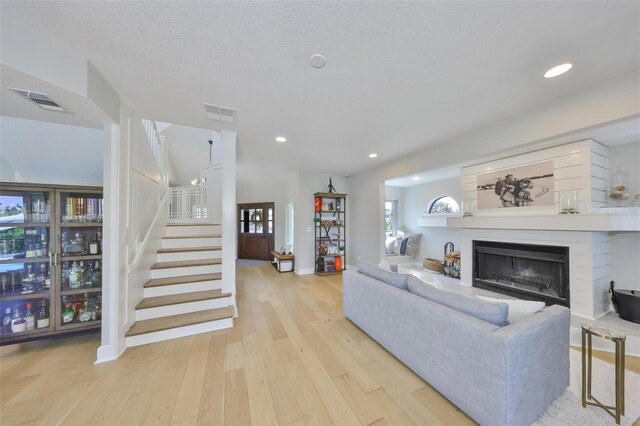 945 Bunker View Dr, Apollo Beach, FL 33572 - living room featuring visible vents, a fireplace, stairway, light wood-type flooring, and recessed lighting