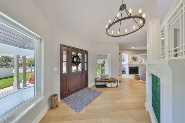 945 Bunker View Dr, Apollo Beach, FL 33572 - entryway featuring light wood-style floors, baseboards, a chandelier, and a fireplace