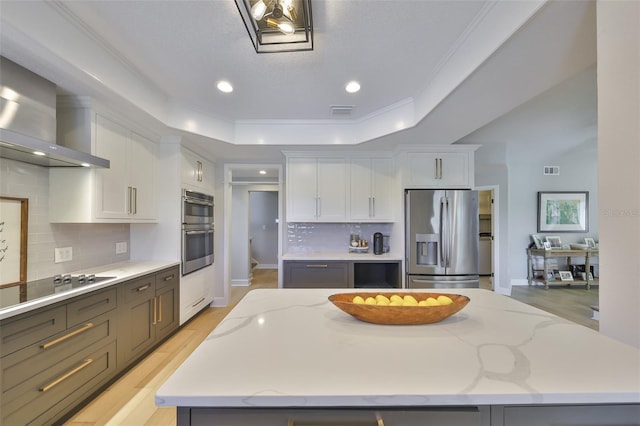 945 Bunker View Dr, Apollo Beach, FL 33572 - kitchen featuring visible vents, wall chimney range hood, a center island, white cabinetry, and stainless steel appliances
