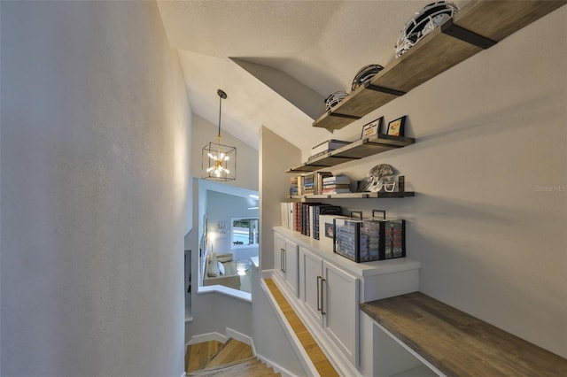 945 Bunker View Dr, Apollo Beach, FL 33572 - hall with baseboards, light wood finished floors, a chandelier, and lofted ceiling