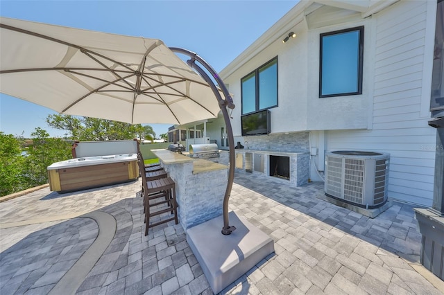 945 Bunker View Dr, Apollo Beach, FL 33572 - view of patio / terrace featuring a hot tub, an outdoor kitchen, cooling unit, and outdoor wet bar